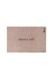 Rectangular pink doormat with the text "shoes off" printed on it. The doormat is placed on a white floor with a pair of blue shoes next to it.