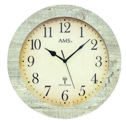 A round, analog wall clock with a white face and black numbers and hands. The clock has a wooden frame with a distressed, light green finish. The clock face displays the AMS brand name at the top.