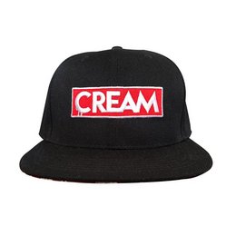  A black snapback cap with the word "CREAM" printed in red on the front panel. The cap has a red and white patterned brim.