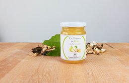 Pear and ginger jam in a glass jar. The jar has a green and white label with the product name "La Golosa di Pere e Zenzero". The jam appears to be a light yellow color. Surrounding the jar are some whole pears and ginger root.