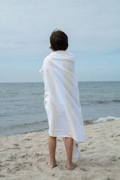 Super light cotton beach towel in white color, perfect for drying off after a day at the beach.