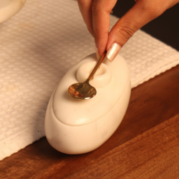 White marble twin serving platter with gold spoon, lid, round shape, elegant kitchen accessory.