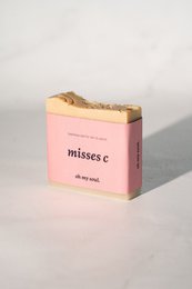 A pink rectangular soap bar with the text "misses c - the perfume bar" printed on the packaging.
