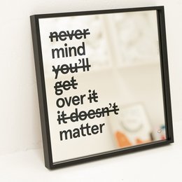 Square mirror with a black aluminum frame, available in multiple sizes. The mirror features a motivational text that says "Never mind you'll get over it it doesn't matter".