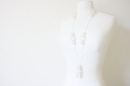 White medium-sized necklace charm with delicate details.