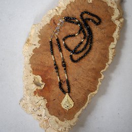  Black obsidian beaded necklace with a Buddha pendant, featuring a natural stone pendant and a long, layered design.