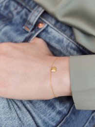 A delicate gold-toned charm bracelet with a heart-shaped charm, perfect for adding a touch of love to any outfit.