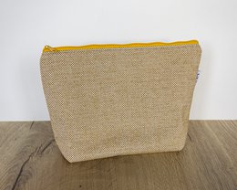 A yellow toiletry bag made of durable, textured material.