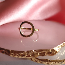 Gold-tone stainless steel ring with circular design, suitable for stacking with other rings.