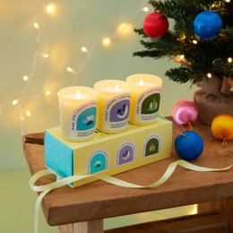 Aromatherapy Candle Gift Set - A set of 3 scented candles in a wooden tray with colorful labels. The candles feature various nature-inspired designs and are presented in a gift-ready packaging.