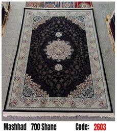 Large dark blue area rug with intricate floral and geometric patterns, suitable for living rooms or bedrooms.
