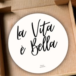 Round white decorative plate with black text "La Vita e Bella" in a cursive font.