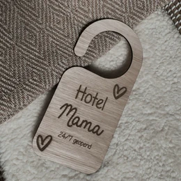 Wooden pendant door hanger with "Hotel Mama" text and heart symbol, made of natural materials, suitable for hotel or home decor.