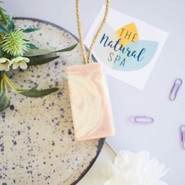 Handcrafted natural soap on a rope with floral accents, available in paper wrap or naked variants.
