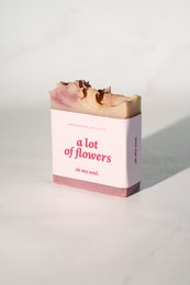A floral-scented soap bar with a pink and gold packaging design.