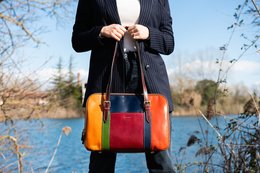 Colorful leather handbag with contrasting panels and gold-tone hardware.