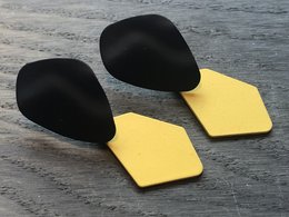 Black drop earrings with yellow hexagonal accents.