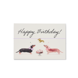  A birthday card featuring a hand-drawn illustration of three dachshund dogs with the text "Happy Birthday!" written above them.