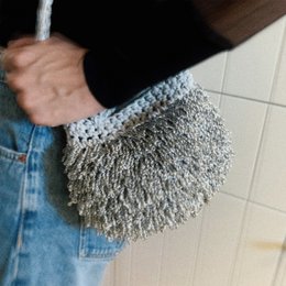 “Pebble metallic” crochet clutch with crossbody strap silver
