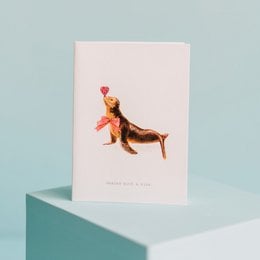 Sealed with a kiss greeting card featuring a plush brown bear holding a heart-shaped balloon. The card is designed for love and romance.