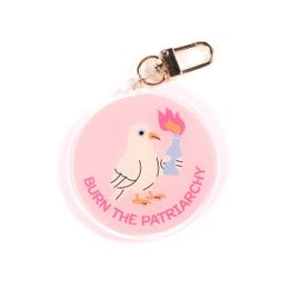 Acrylic keychain with a pink circular design featuring a cartoon chicken and the text "Burn the patriarchy". The keychain has a metal ring for attaching to keys or bags.