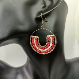 Hoop earrings with a U-shaped design featuring red and gold beads. The earrings have a modern, stylish appearance.