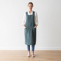 Linen back cross apron in balsam green stone washed color. Durable and stylish apron made of high-quality linen fabric with a cross-back design for a comfortable fit.
