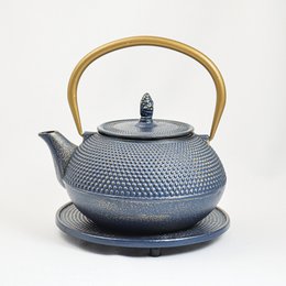 A cast iron teapot in a blue and gold color, with a capacity of 1.2 liters. The teapot has a round, textured body and a wooden handle.