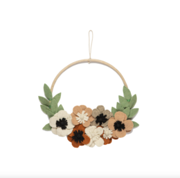  A round wooden wall hanging with a floral arrangement of colorful felt flowers in shades of yellow, orange, and brown. The flowers are surrounded by green felt leaves and the hanging is suspended by a white cord.