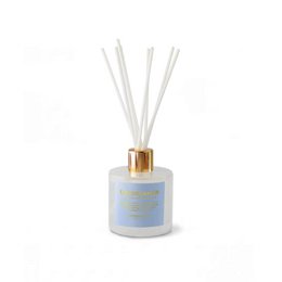 White cylindrical scented candle with gold lid, blue label, luxury home fragrance, aromatic decor.
