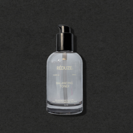 Balancing toner in a clear glass bottle with a black pump dispenser. The toner is designed to balance and hydrate the skin.