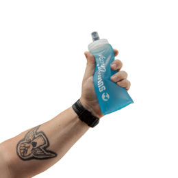 A blue, soft, wide-neck water bottle with a cap. The bottle is being held in a hand with a tattoo on the wrist.