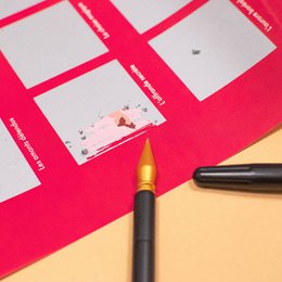 Scratch-off poster stylus pen with gold tip, black barrel, interactive art tool for revealing hidden designs.