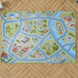 The STUTTGART play mat is a colorful and detailed kids rug featuring a map-like design with roads, buildings, and various elements like trees and vehicles. The rug is available in two sizes, 180 x 130cm (L) and 150 x 100 cm (M2), and is suitable for use in a child's playroom or bedroom.