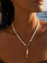 Pearl beaded necklace with gold shell pendant, coastal beach style jewelry.