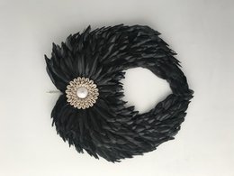 Black feathered angel wing wreath with a decorative pearl center.