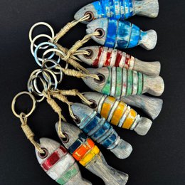 Colorful fish-shaped keychains made of plastic with various patterns and designs. The keychains feature vibrant colors such as blue, orange, and green, and have a playful, whimsical appearance.