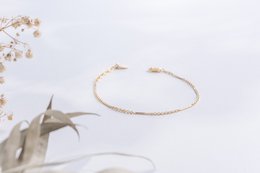 Delicate gold-toned bracelet with intricate chain design, suitable for everyday wear.