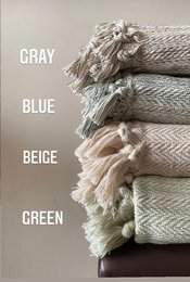 Handwoven throw blanket in gray, blue, beige, and green colors with a textured, fringed design.