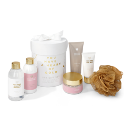 A spa gift set containing a variety of beauty products, including a pink bottle, a white jar, and a gold-colored bottle. The set appears to be designed for relaxation and pampering.