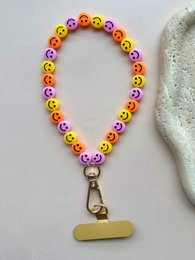 # Product Description

Colorful beaded phone cord with smiley face beads in yellow, red, pink, and green. Metal clasp attachment.