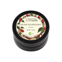 A rich, creamy shea and cocoa butter balm in a round black container with a decorative label featuring leaves and berries.