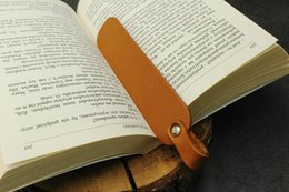 Leather bookmark, available in black and cognac colors, designed to hold your place in a book.