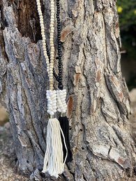 Wooden pendant necklace with shells and tassel in white color.