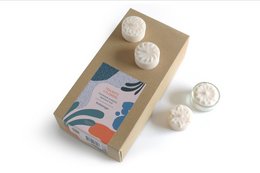 25 rapeseed wax tea lights in a box with floral design. Cream-colored round tea lights with a natural, organic appearance.