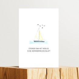 Folded handmade paper card with a simple illustration of a boat and text in Dutch. The card is intended for condolences or sympathy.