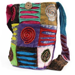 Colorful, patchwork-style sling bag with spiral and floral designs, made of various textured fabrics in vibrant hues.