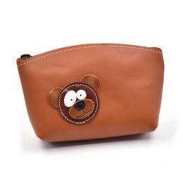 A handmade full grain leather makeup bag in a warm brown color, featuring a cute raccoon design applique.