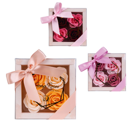 A set of 4 rose-scented bath confetti and soap rose gift boxes in pink, rose, and apricot colors, presented in a light-colored gift box with a pink ribbon.