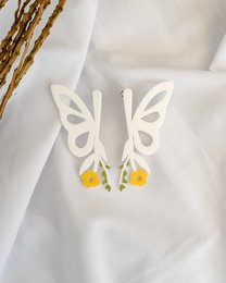 White butterfly-shaped drop earrings with yellow accents.